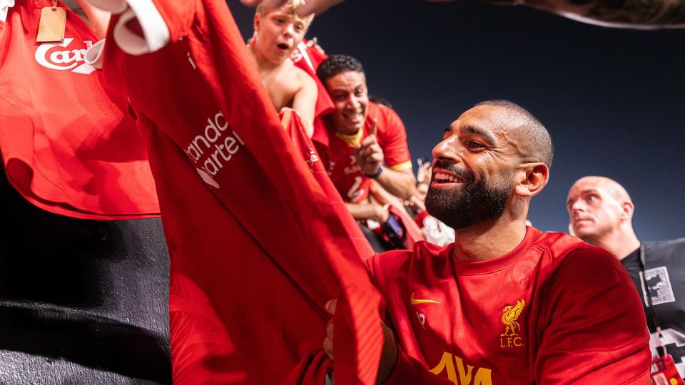 Mohamed Salah signing a Liverpool shirt for fans